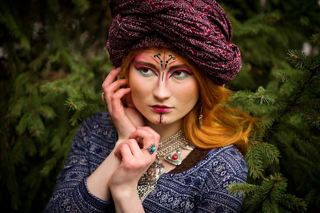 Retrato de uma jovem linda em um turbante no jardim de outono