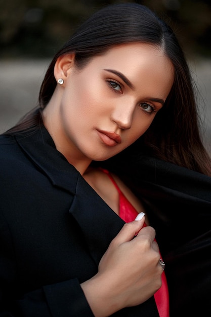 Retrato de uma jovem linda em uma jaqueta preta e vestido vermelho na rua profundidade rasa de foco seletivo