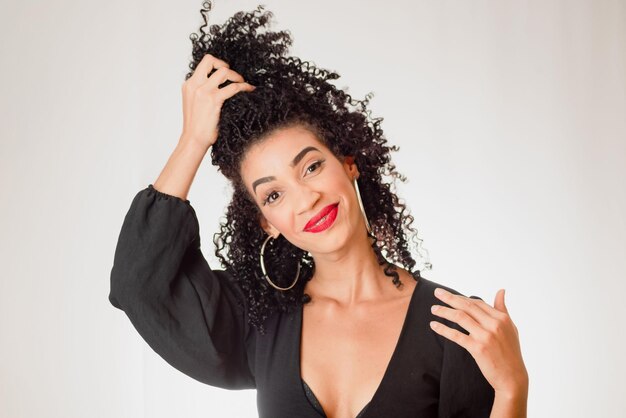 Foto retrato de uma jovem linda mulher sorridente com a mão no cabelo.