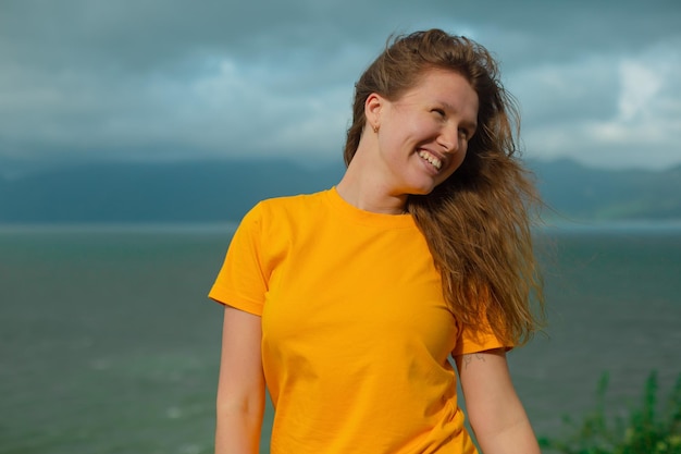 Retrato de uma jovem linda que viaja caminhando com uma mochila na vista das montanhas em