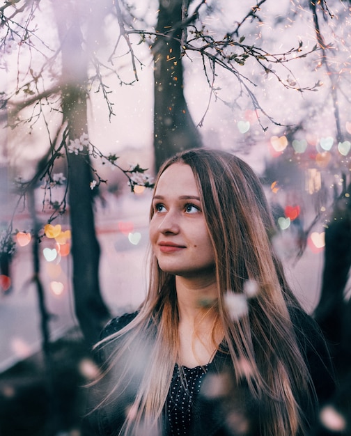 Retrato de uma jovem loira com fundo desfocado com bokeh de corações