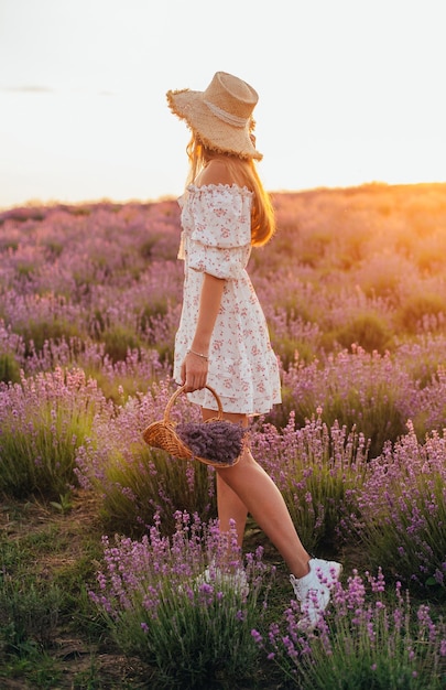 Retrato de uma jovem loira em um campo de lavanda no verão ao pôr do sol