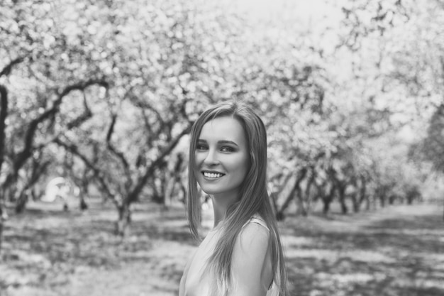 Retrato de uma jovem loira em um vestido azul. árvores em flores.