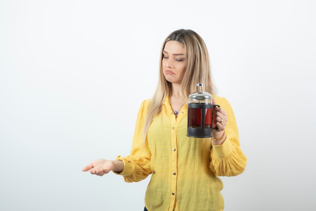 Retrato de uma jovem loira segurando um bule de chá quente