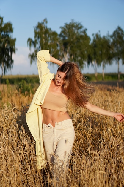 Retrato de uma jovem loira sorridente em um fundo de campo de trigo dourado