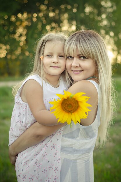 Retrato de uma jovem mãe loira com sua filha nos braços