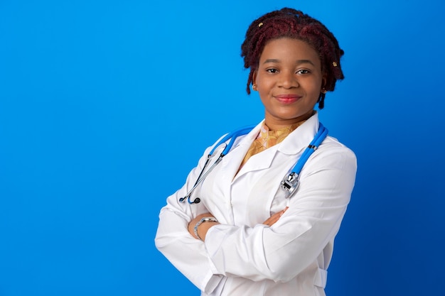 Retrato de uma jovem médica afro-americana contra um fundo azul.