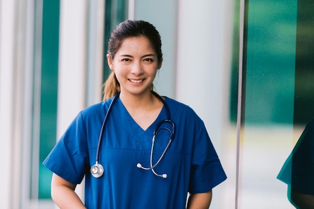 Retrato de uma jovem médica asiática do lado de fora do prédio do hospital com estetoscópio