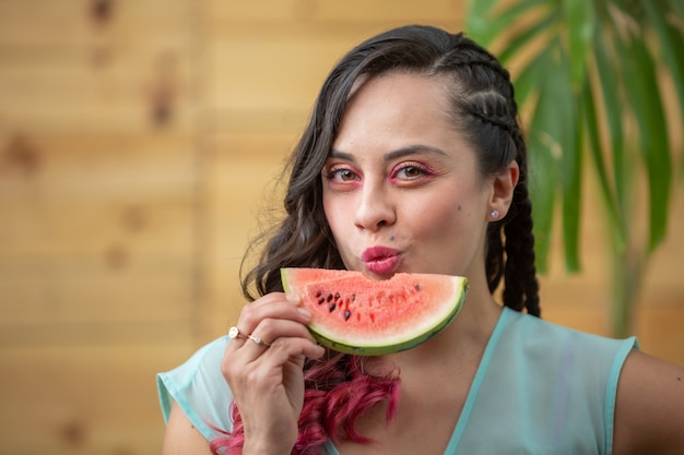 Retrato de uma jovem mexicana no verão comendo uma fatia de melancia