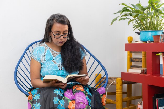 Retrato de uma jovem mexicana vestindo roupas de tehuana, lendo e estudando