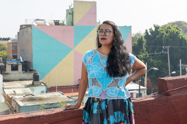 Retrato de uma jovem mexicana vestindo roupas de tehuana, lendo e sorrindo