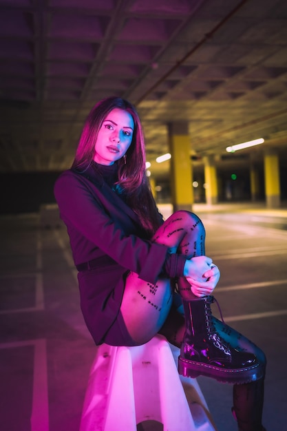 Retrato de uma jovem modelo caucasiana morena à noite em um estacionamento subterrâneo
