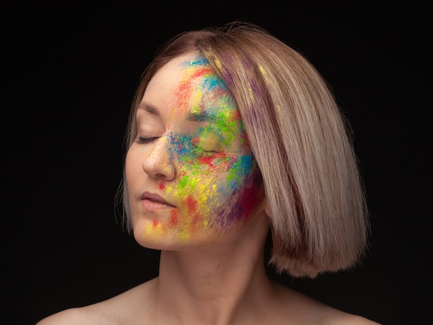 Foto retrato de uma jovem modelo com mistura colorida brilhante de tinta.