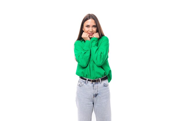 Foto retrato de uma jovem modelo feminina europeia sorridente e confiante com cabelos pretos bem cuidados e maquiagem vestida com uma camisa verde