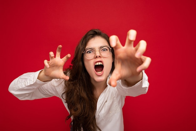 Retrato de uma jovem morena atraente emocional com emoções sinceras, vestindo branco casual