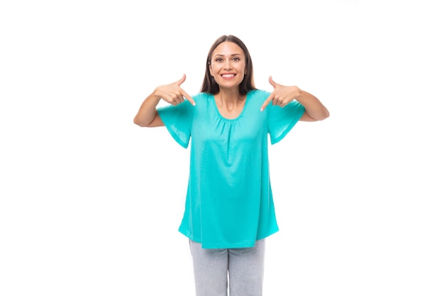 Foto retrato de uma jovem morena caucasiana com cabelos longos em uma camiseta azul mostrando com ela