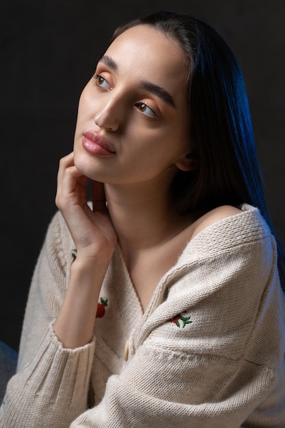 Retrato de uma jovem morena com cabelo comprido no estúdio Foto dramática em cores escuras