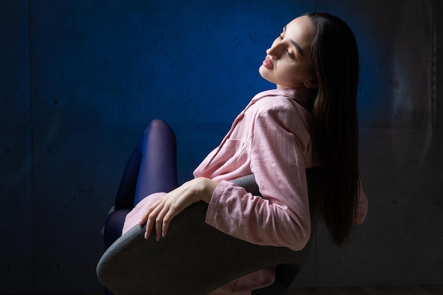 Retrato de uma jovem morena com cabelo comprido no estúdio Foto dramática em cores escuras