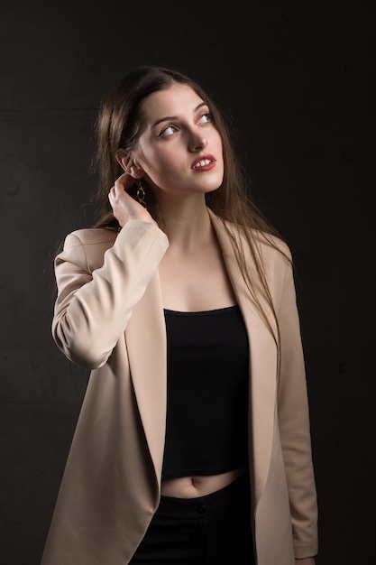 Retrato de uma jovem morena com cabelo comprido no estúdio Foto dramática em cores escuras