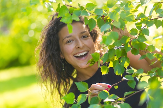 Retrato de uma jovem morena linda desfrutar de um passeio no parque verde de verão.