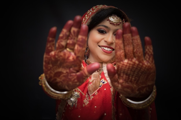 Foto retrato de uma jovem mostrando uma tatuagem de henna durante a cerimônia de casamento