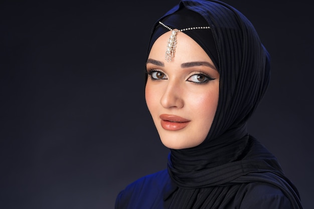 Retrato de uma jovem muçulmana em um hijab na superfície preta