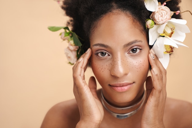 Retrato de uma jovem mulher afro-americana seminua e sardenta com flores no cabelo