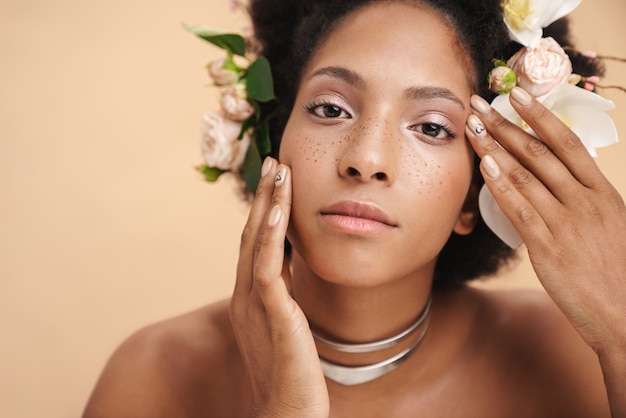 Retrato de uma jovem mulher afro-americana seminua e sardenta com flores no cabelo