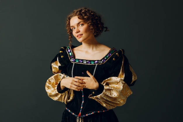 Retrato de uma jovem mulher aristocrática vestida com um vestido medieval de cosplay em fundo escuro