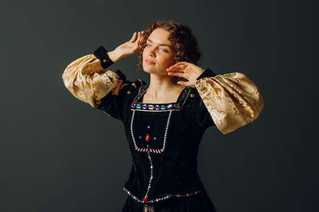 Foto retrato de uma jovem mulher aristocrática vestida com um vestido medieval em fundo escuro