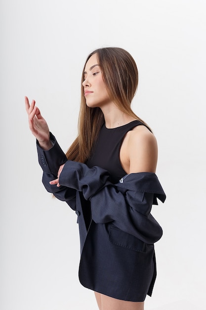 Retrato de uma jovem mulher asiática atraente com cabelo comprido em bodysuit preto e terno azul, isolado no fundo branco do estúdio. mulher bonita magra posando no ciclorama. testes de modelo de bela senhora