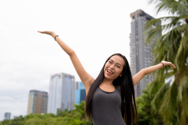 Retrato de uma jovem mulher asiática bonita relaxando no parque em Bangkok, Tailândia