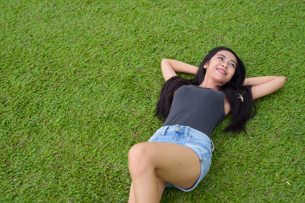 Retrato de uma jovem mulher asiática bonita relaxando no parque em Bangkok, Tailândia