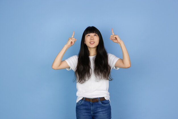 Retrato de uma jovem mulher asiática isolada no fundo azul do estúdio