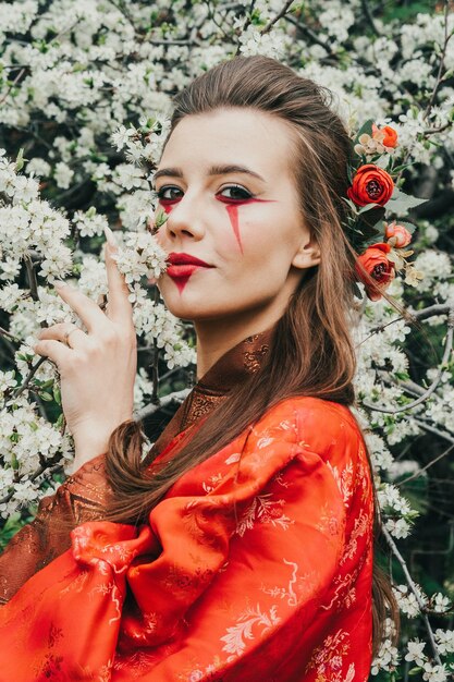 Retrato de uma jovem mulher asiática usando quimono. Beleza asiática. Flores de cerejeira. Hanami. Conceito de turismo do Japão.