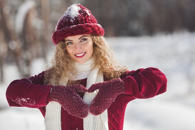 Retrato de uma jovem mulher atraente ao ar livre no inverno, mostrando o coração de papel