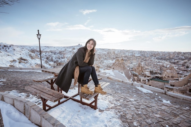 Retrato de uma jovem mulher atraente feliz na capadócia nevada