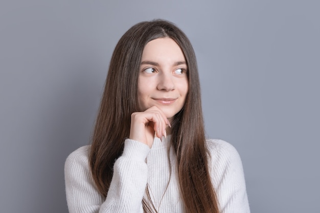 Retrato de uma jovem mulher bonita com cabelo escuro e suéter branco