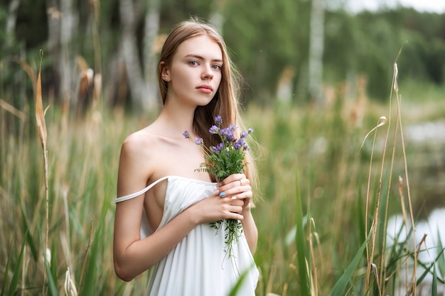 Retrato de uma jovem mulher bonita com flores silvestres