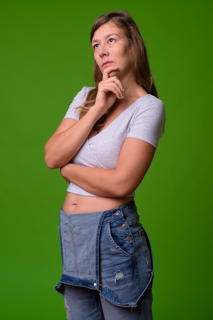 Retrato de uma jovem mulher bonita contra uma parede verde