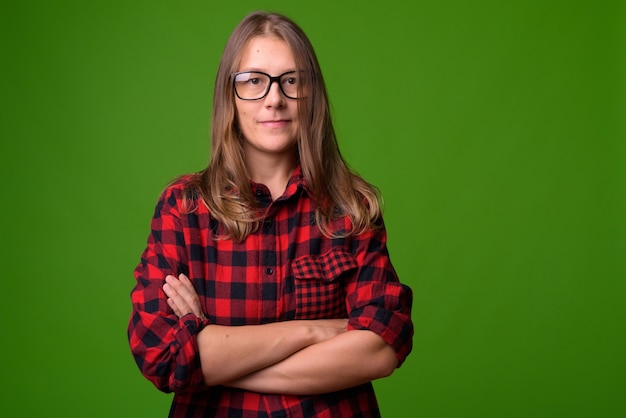 Retrato de uma jovem mulher bonita contra uma parede verde