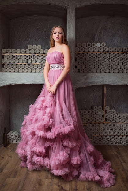 Retrato de uma jovem mulher bonita em um vestido longo rosa