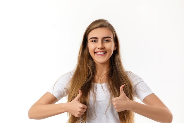 Retrato de uma jovem mulher bonita mostrando os polegares para cima