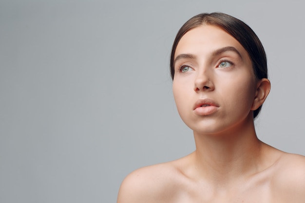 Retrato de uma jovem mulher bonita positiva com maquiagem nude.