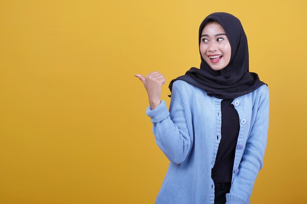 Retrato de uma jovem mulher bonita usando hijab, sorrindo com alegria e parecendo feliz, sentindo-se despreocupada e positiva com os dois polegares para cima