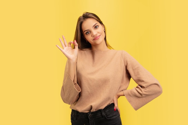 Retrato de uma jovem mulher branca com emoções brilhantes isoladas em amarelo