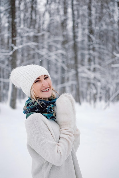 Retrato de uma jovem mulher caucasiana andando sozinha no parque ou floresta no dia de inverno nevado