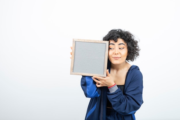 Foto retrato de uma jovem mulher com cabelo encaracolado, com pé de moldura.