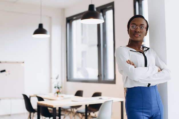 Foto retrato de uma jovem mulher de negócios americano africano no escritório moderno apartamento