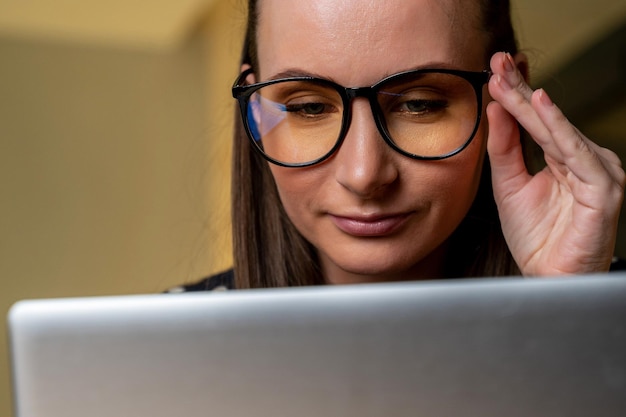 Retrato de uma jovem mulher de negócios com óculos trabalhando com um computador no escritório closeup O conceito de negócios de tecnologia e sucesso de gestão de economia financeira